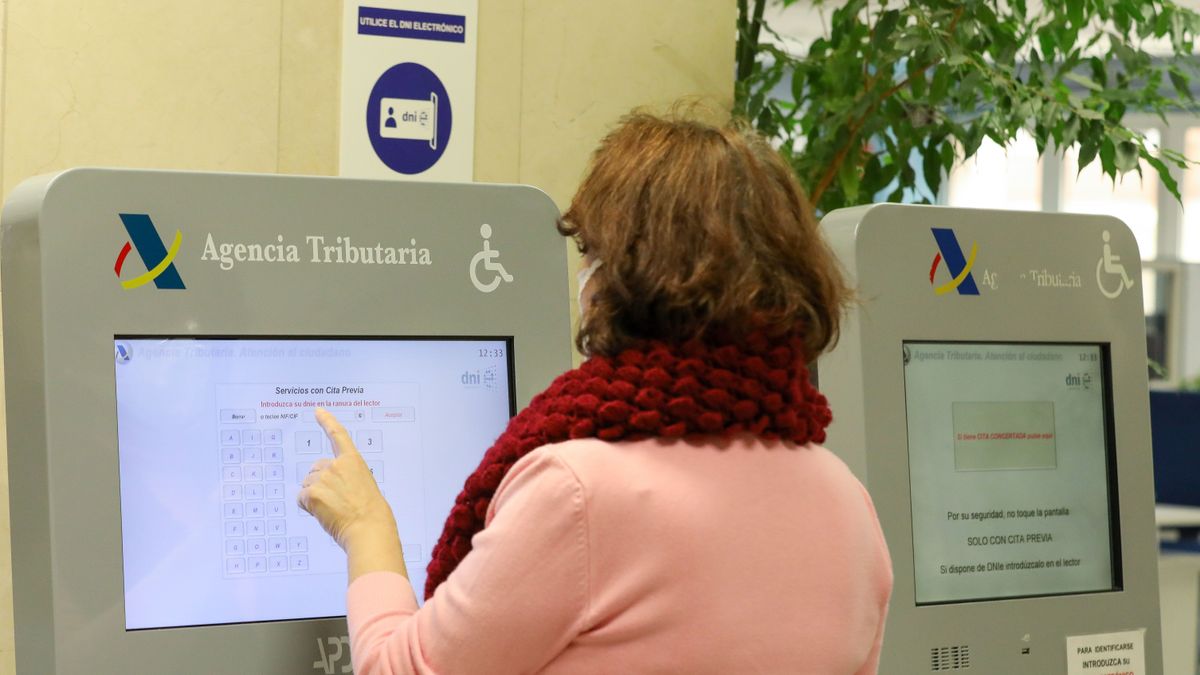 Una mujer recoge su turno en una oficina de la Agencia Tributaria, a 5 de abril de 2022, en Madrid (España)