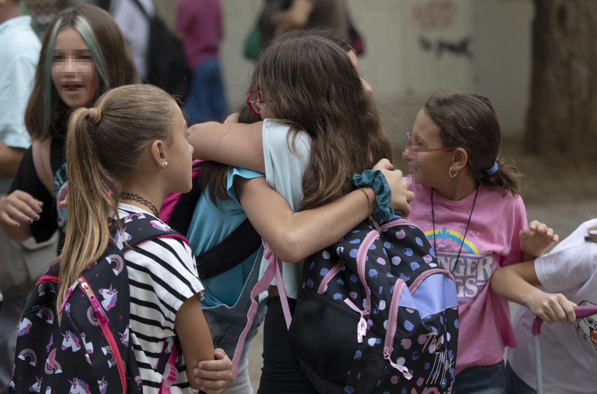 Dos alumnas del CEIP Escritor Alfonso Grosso se abrazan durante el primer día de colegio tras las vacaciones de verano.