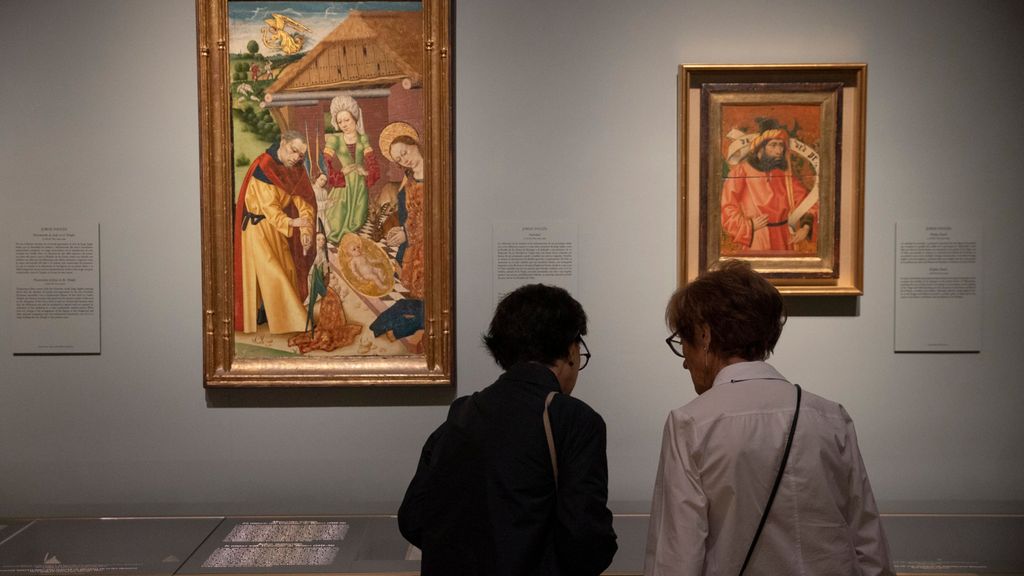 Dos mujeres frente a dos de las obras de la exposición 'Marqués de Santillana' en el Museo del Prado