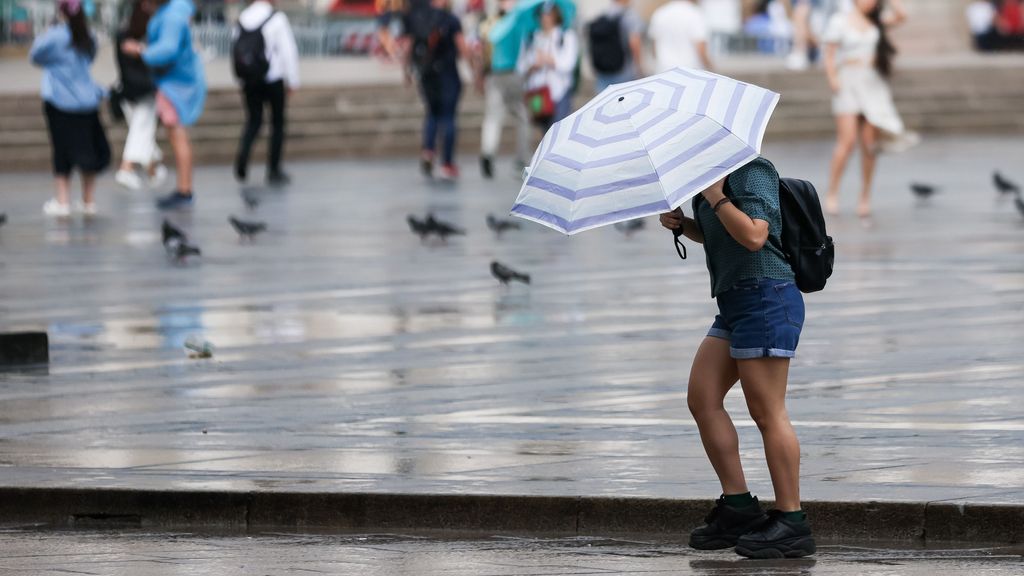 EuropaPress 4537327 24 june 2022 italy milan passer by uses an umbrella to protect herself from