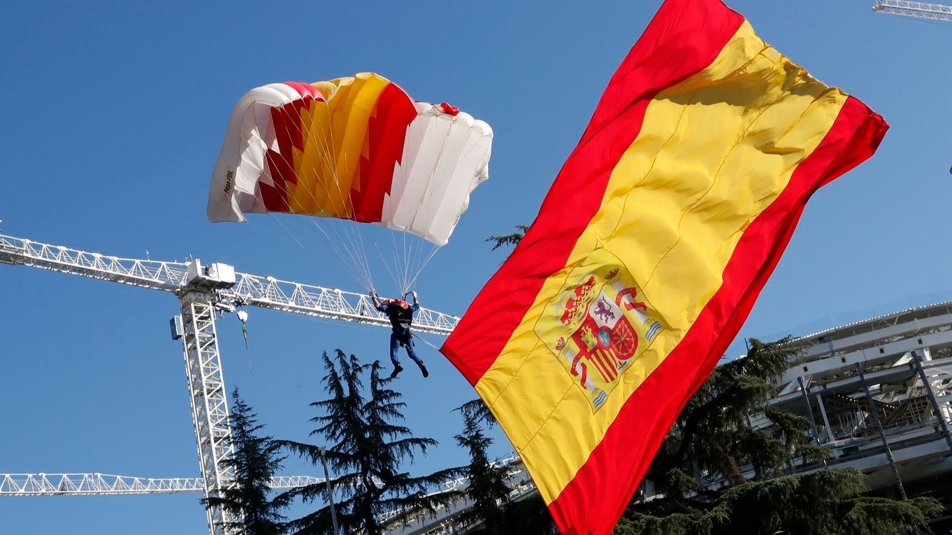 El salto de los paracaidistas portando la bandera de España en el desfile del 12 de Octubre