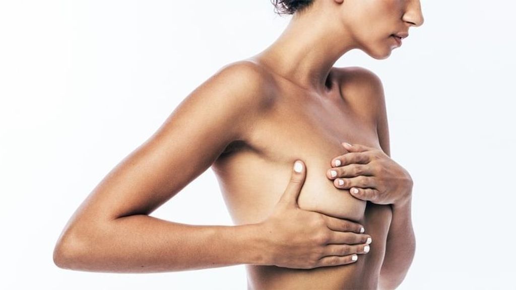 Una mujer se palpa el pecho