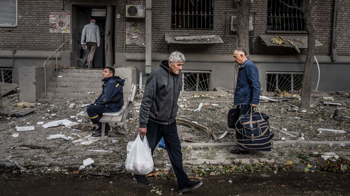 Civiles ucranianos frente a un edificio destruido por el Ejército ruso