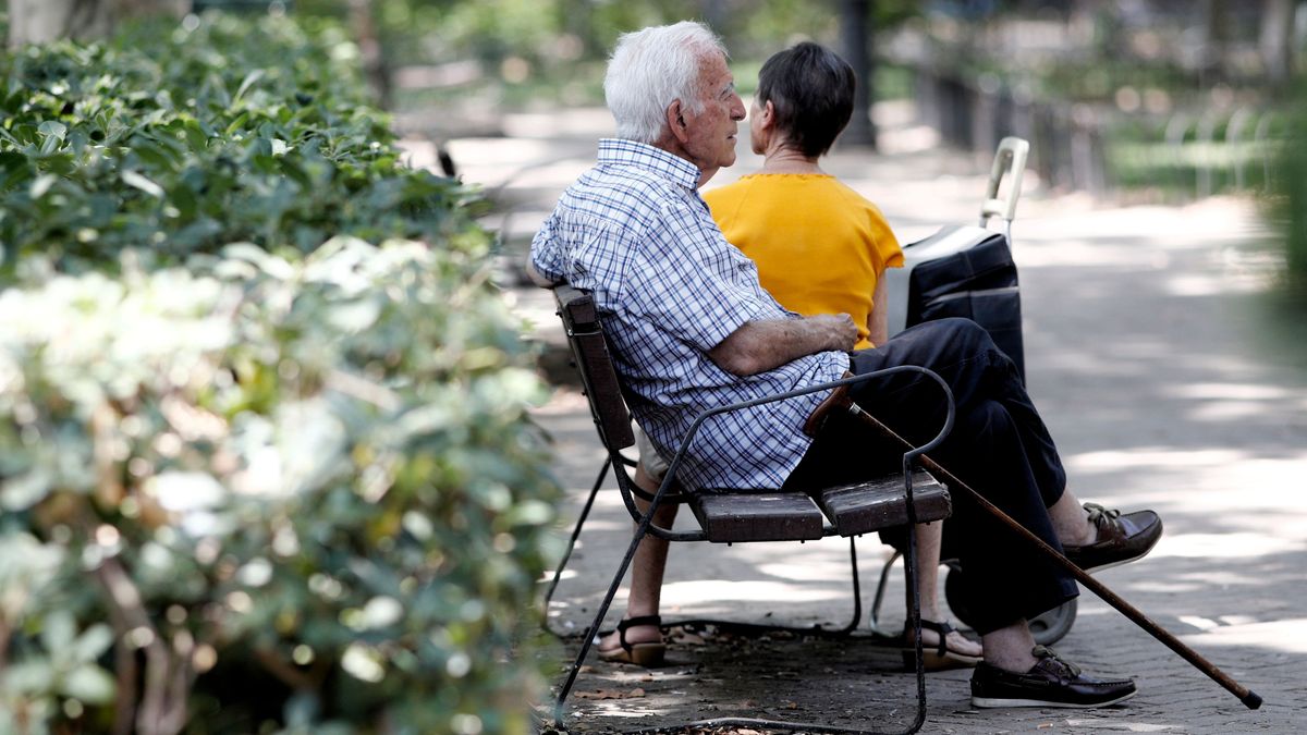 Pensionistas descansan en un banco de un parque de Madrid