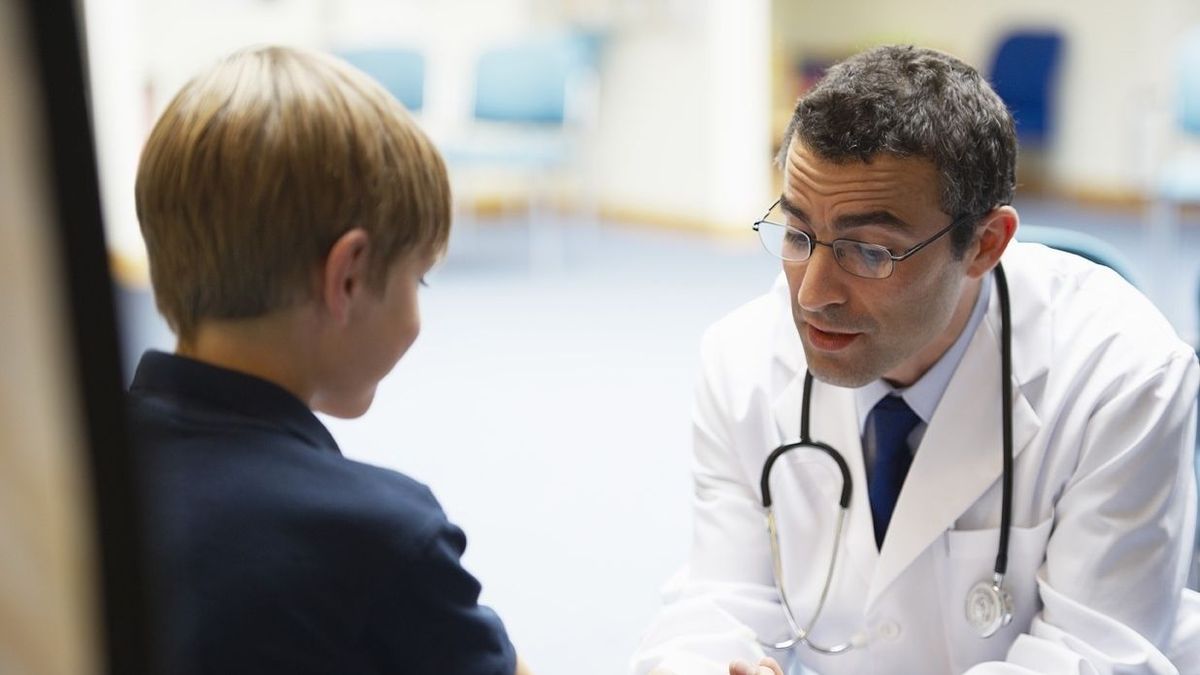 Un médico atiende a un niño en su consulta