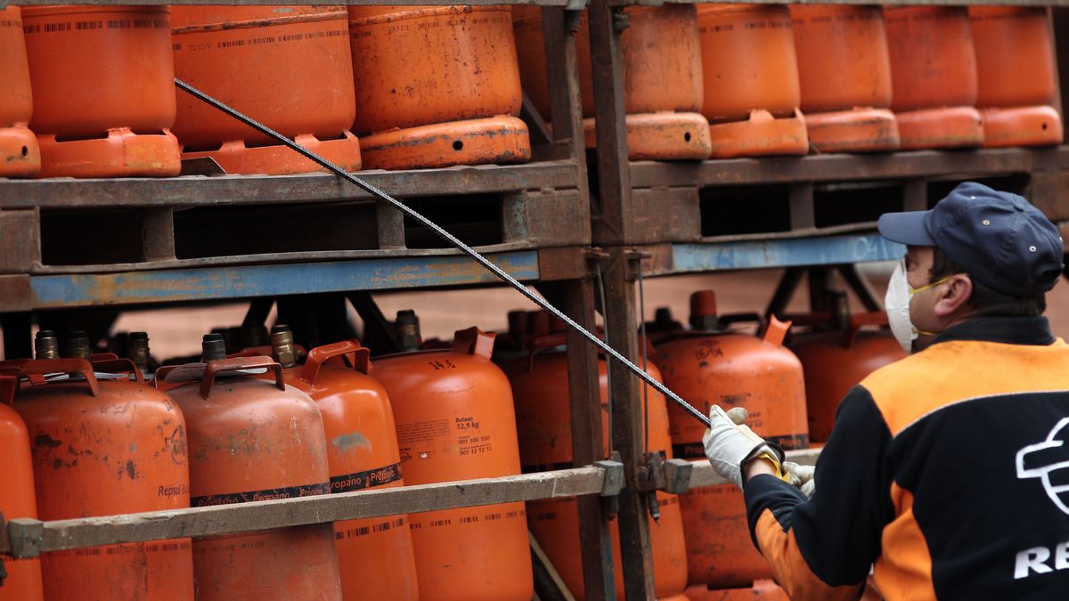 Trabajador coge una bombona de butano Trabajador coge una bombona de butano