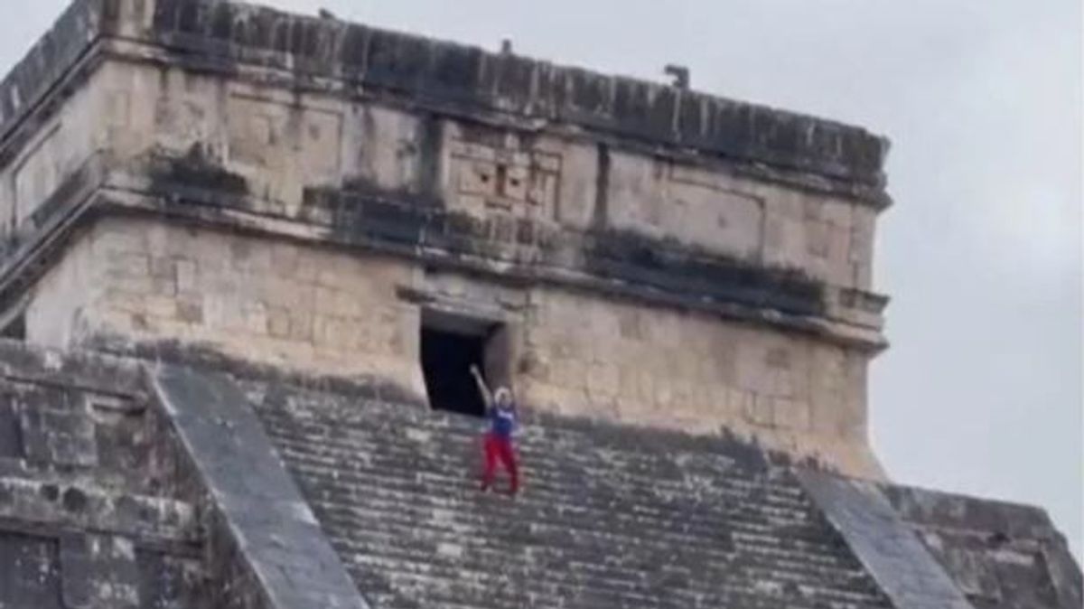 Una turista se sube a la cima de una pirámide maya en México