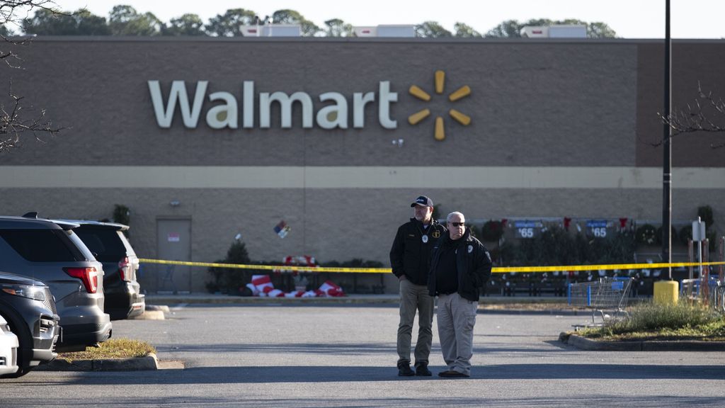 Miembros de la policía permanecen cerca de la escena donde al menos siete personas han muerto después de que un hombre armado abriera fuego en un supermercado Walmart en Chesapeake