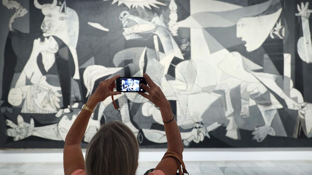 Archivo - Una mujer fotografía la obra de Picasso 'Guernica' en el Museo Reina Sofía