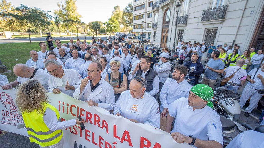 Un grupo de personas pertenecientes al gremio de panaderos y pasteleros de Valencia sostienen una pancarta en una concentración frente a la Delegación del Gobierno para protestar por la crisis del sector