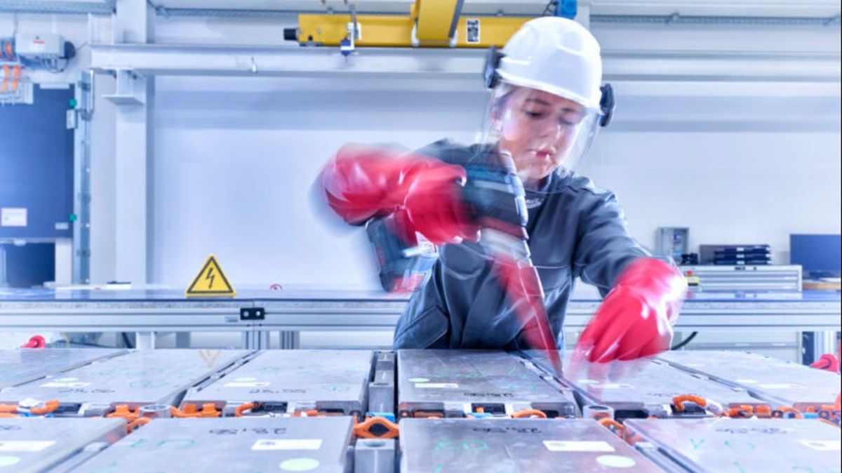Trabajadora de Volkswagen ensamblando baterías Trabajadora de Volkswagen ensamblando baterías