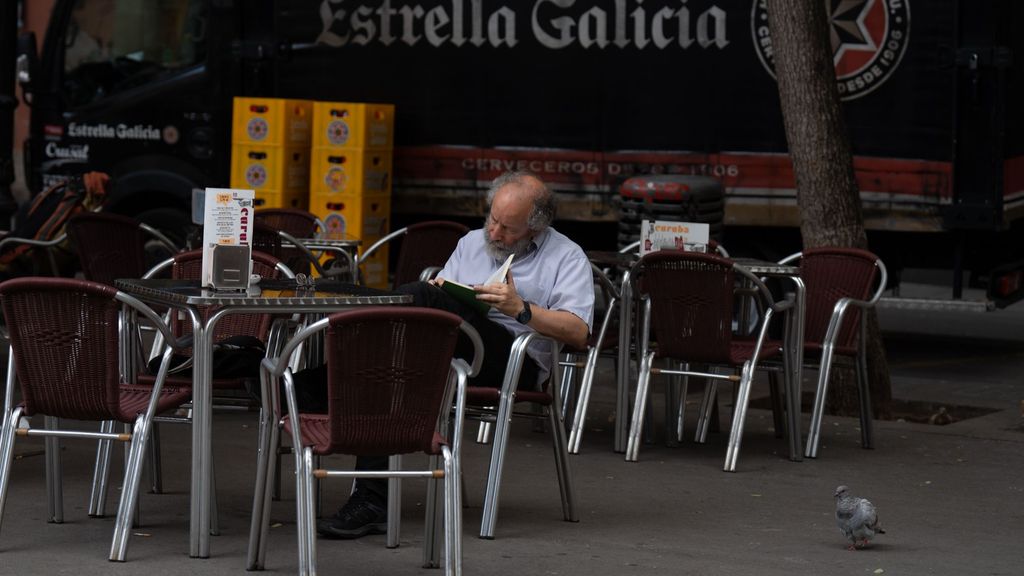 Un hombre lee en una terraza del centro de Barcelona