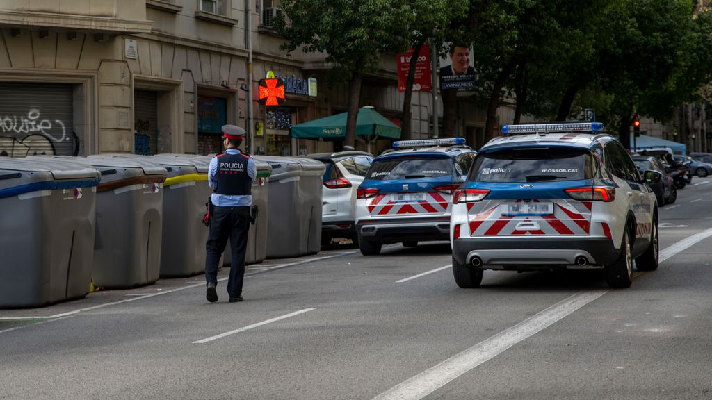 Un Agente de Policía controla la zona donde se ha encontrado un cadáver en un contenedor del centro de Barcelona