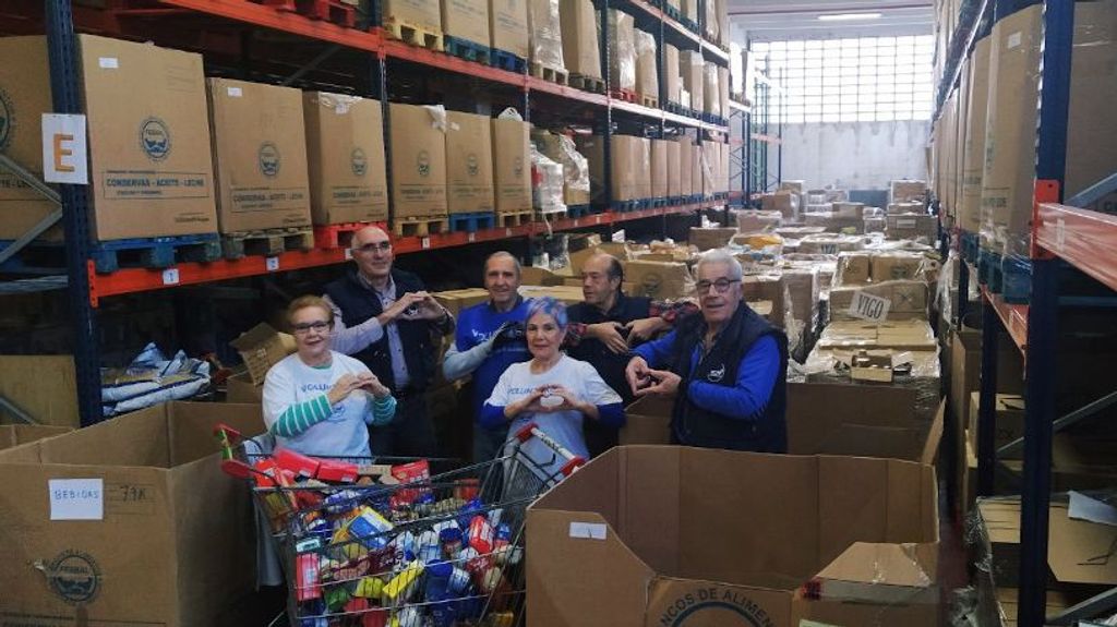 Voluntarios del Banco de Alimentos de Vigo rodeados de cajas.