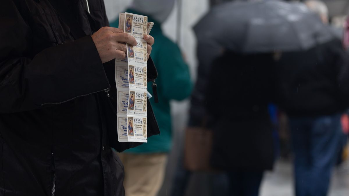 Una persona con varios décimos de Lotería de Navidad. Una persona con varios décimos de Lotería de Navidad.
