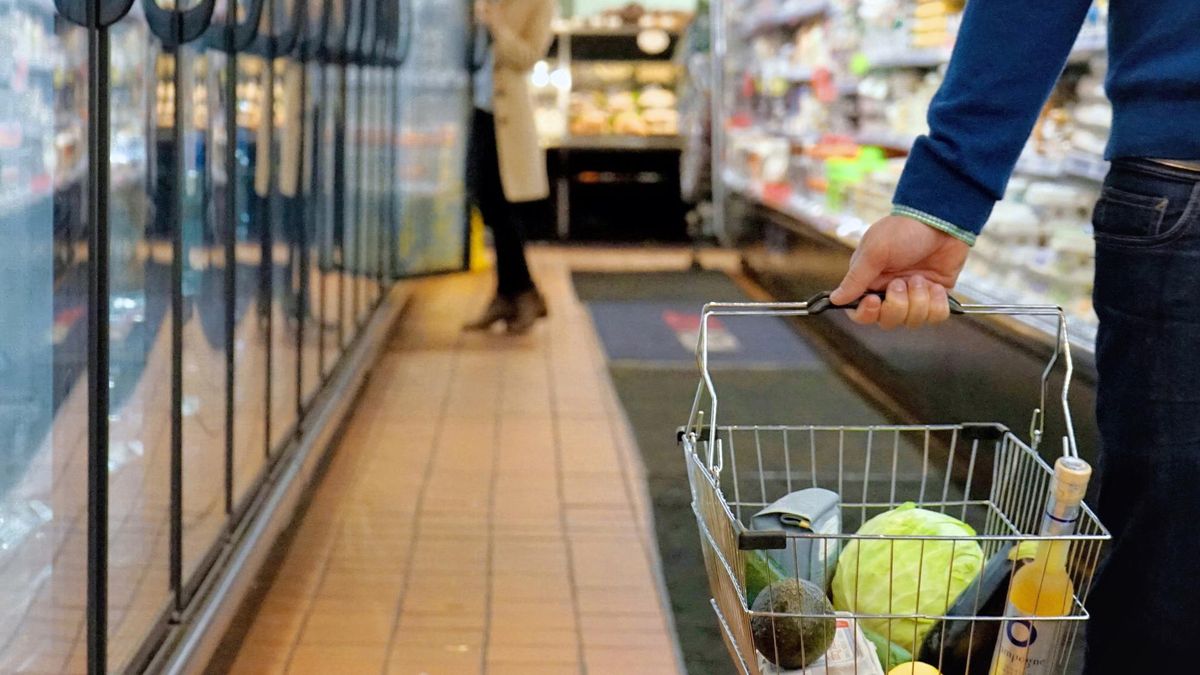 Archivo - Gente comprando en un supermercado con la cesta de la compra