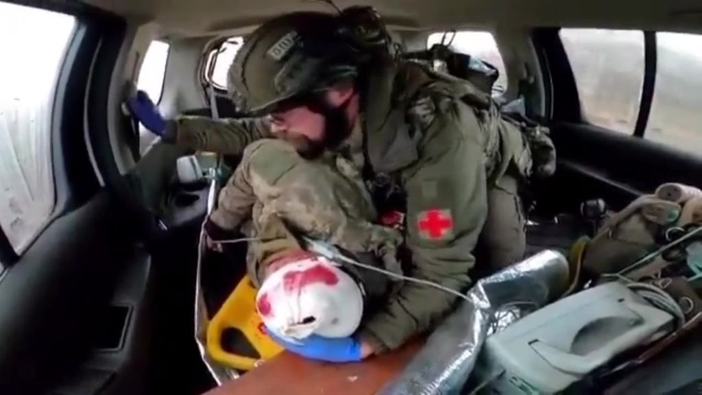 Un médico militar polaco voluntario consuela a un soldado ucraniano herido mientras le traslada a un hospital en Donestk, Ucrania