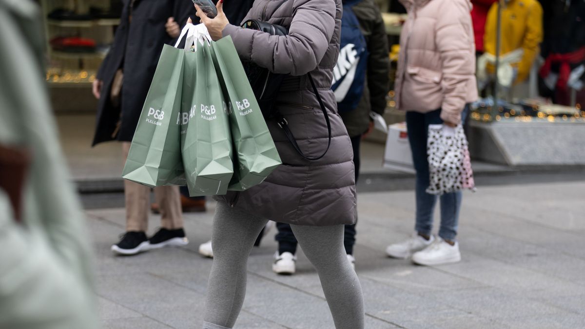 Una persona sujeta varias bolsas con compras de Navidad, a 23 de diciembre de 2022, en Madrid