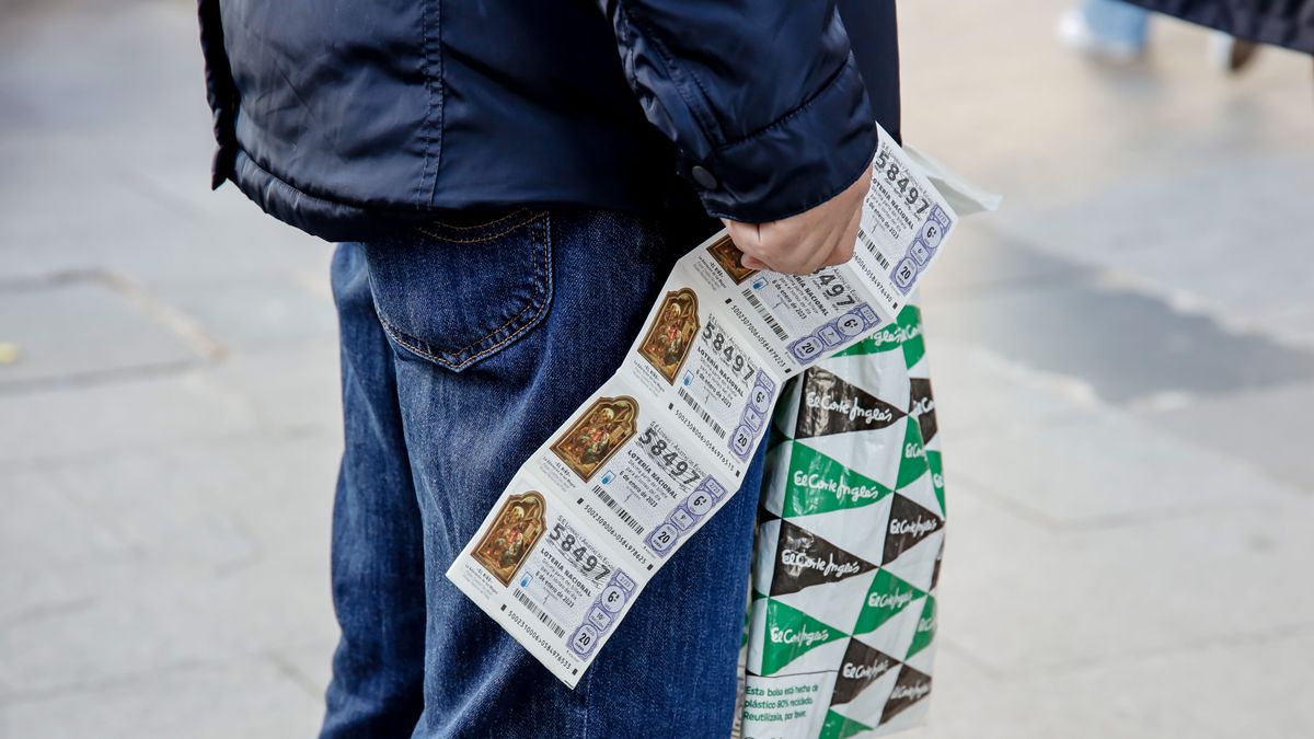 Un hombre sostiene varios décimos de lotería Un hombre sostiene varios décimos de lotería