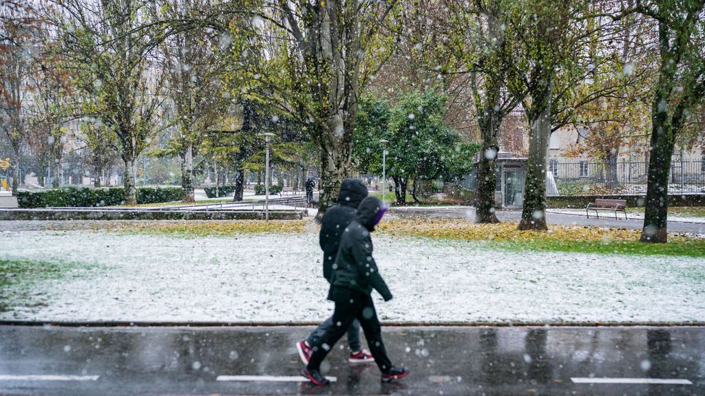 Dos personas caminan bajo la nieve en Vitoria