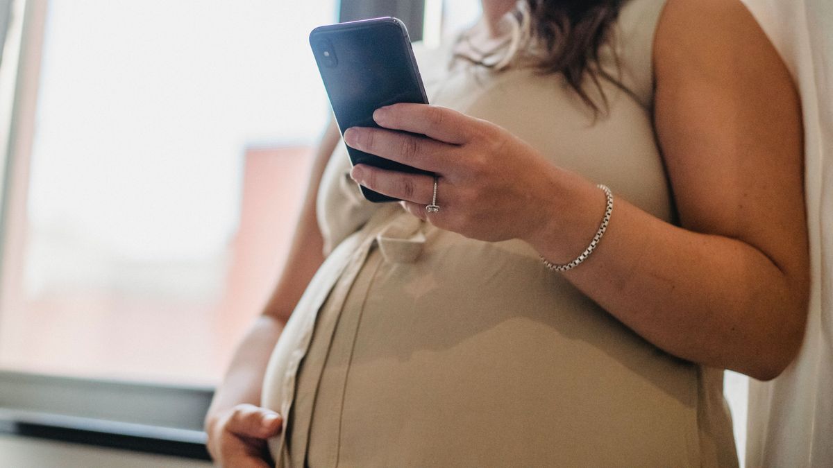 Una mujer embarazada consultando su móvil (Archivo)