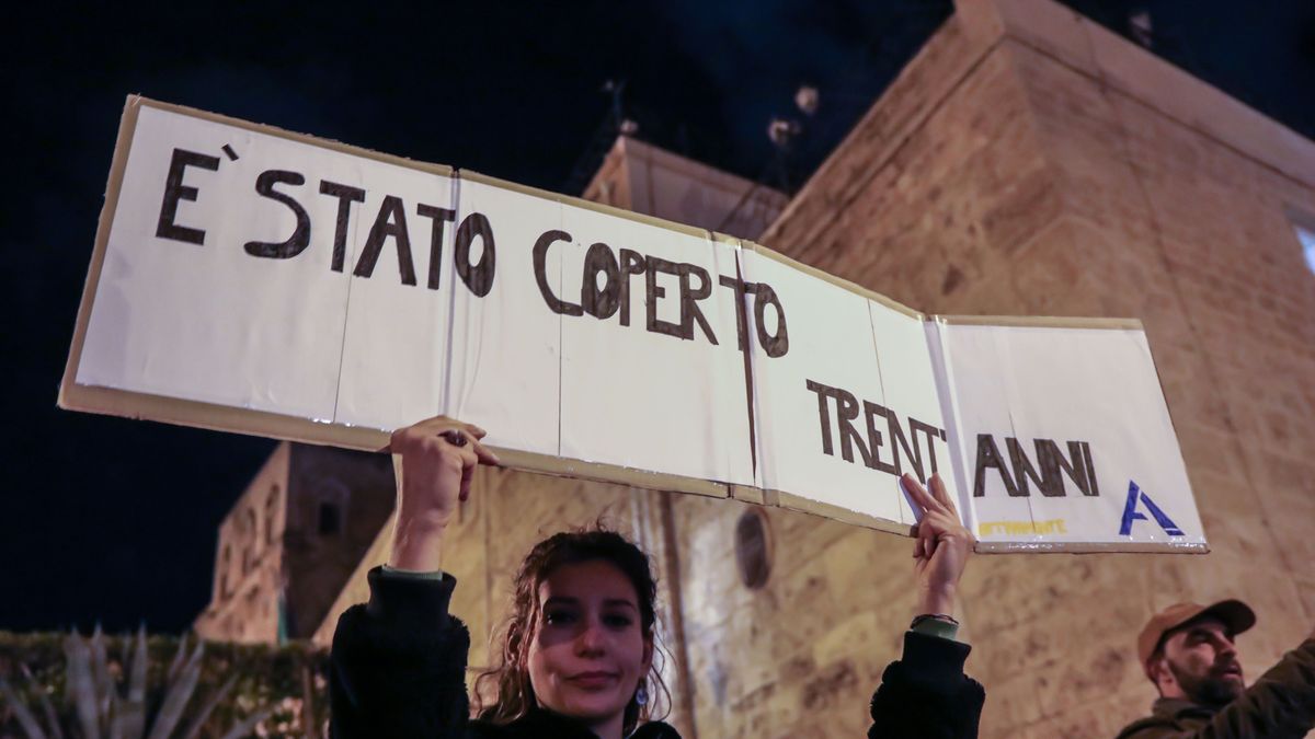 Una joven sostiene un cartel en una manifestación contra la mafia en Palermo que dice "ha estado 30 años encubierto".