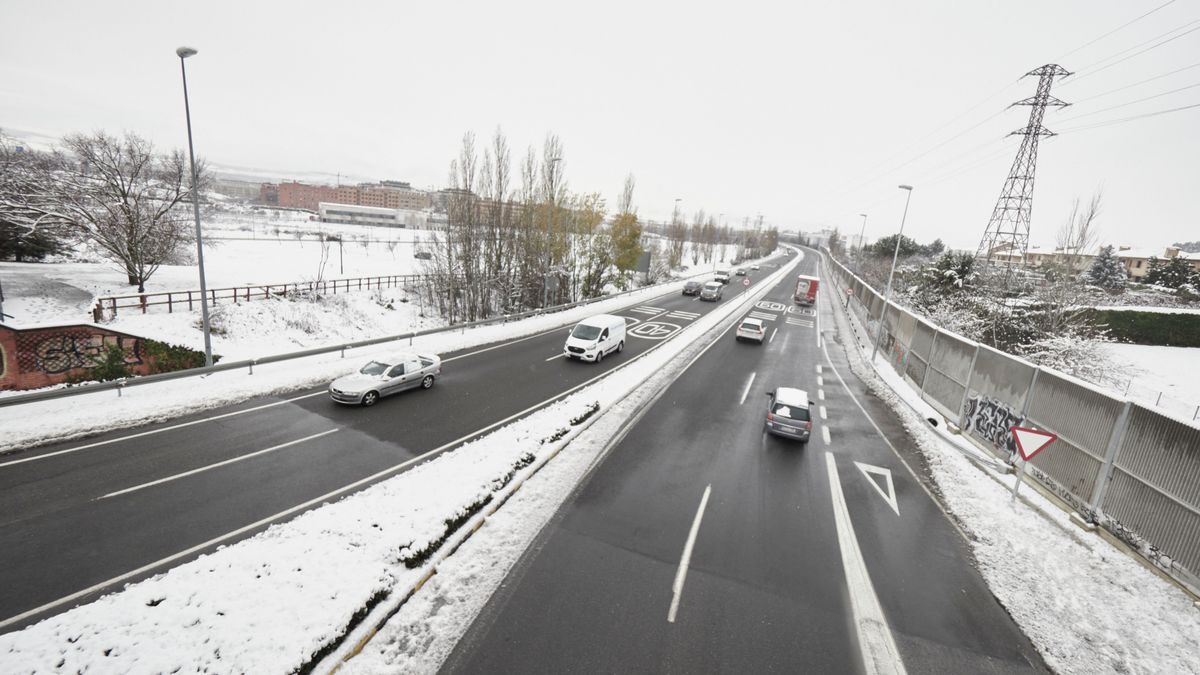 Varios coches circulan por una carretera con los laterales cubiertos de nieve en Pamplona, Navarra (España)