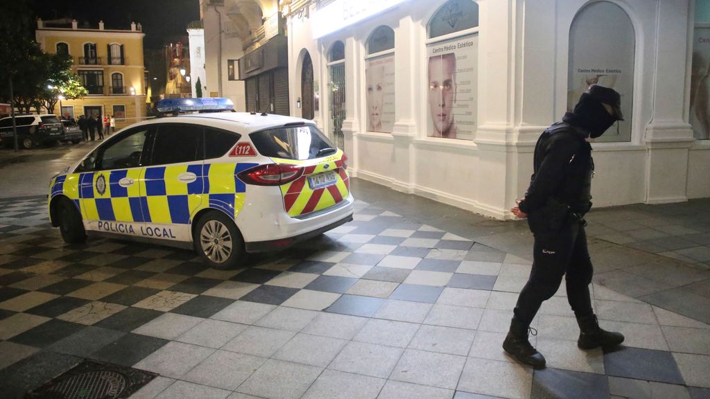 Un policía local corta una calle aledaña a la plaza donde estaba el cadáver del sacristán en Algeciras