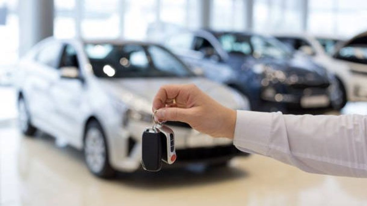 Un hombre adquiere un coche de nueva adquisición en un concesionario Un hombre adquiere un coche de nueva adquisición en un concesionario