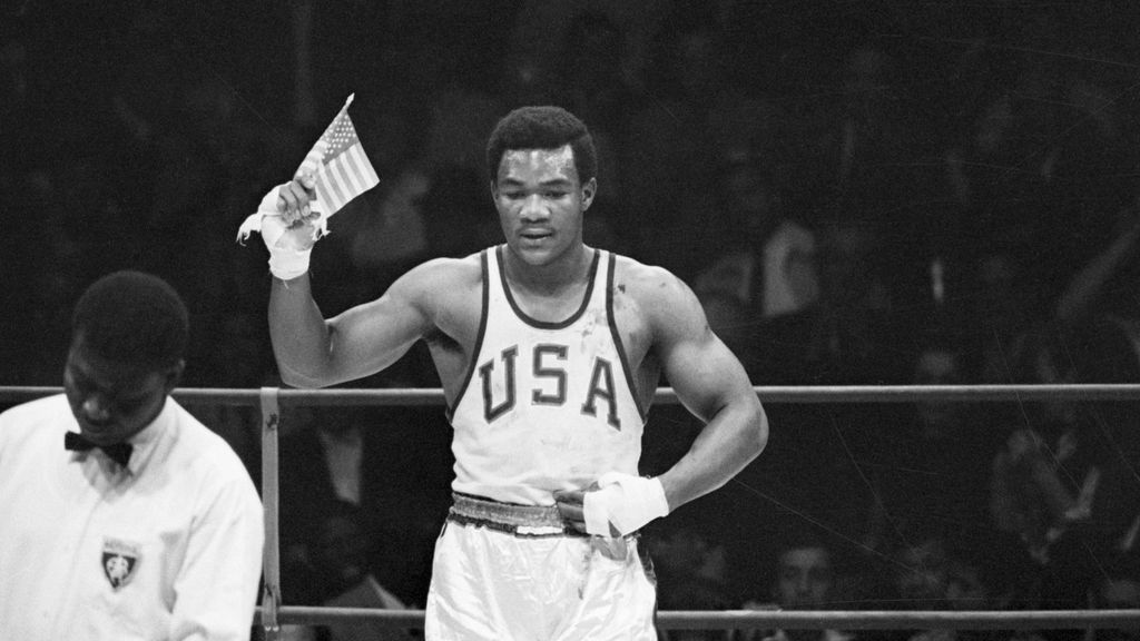 George Foreman de Houston, Texas, ondea una pequeña bandera estadounidense después de ganar la medalla de oro de boxeo de peso pesado en las Olimpiadas
