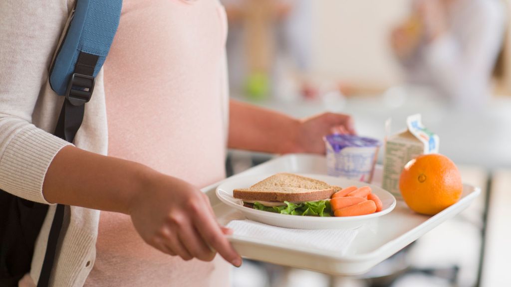 Una estudiante con una bandeja de comida en un comedor de una escuela de EEUU