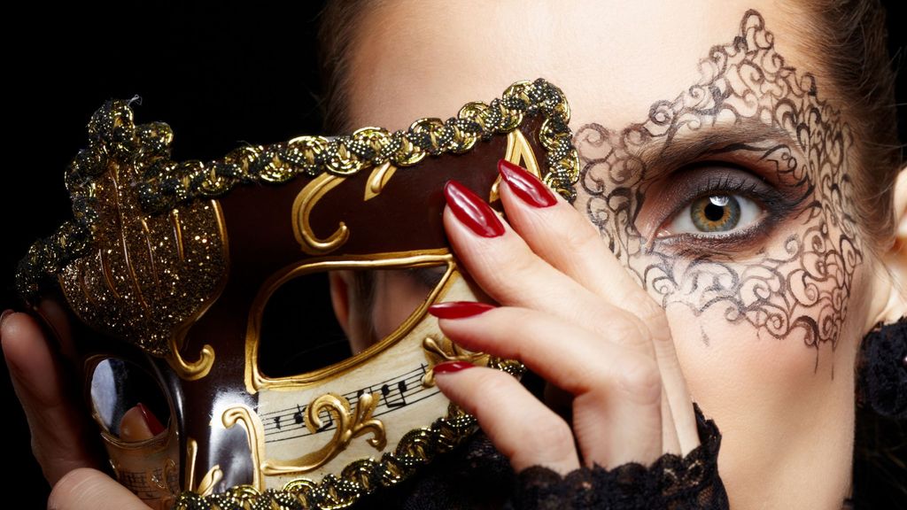 Una mujer maquillada para carnaval con una máscara