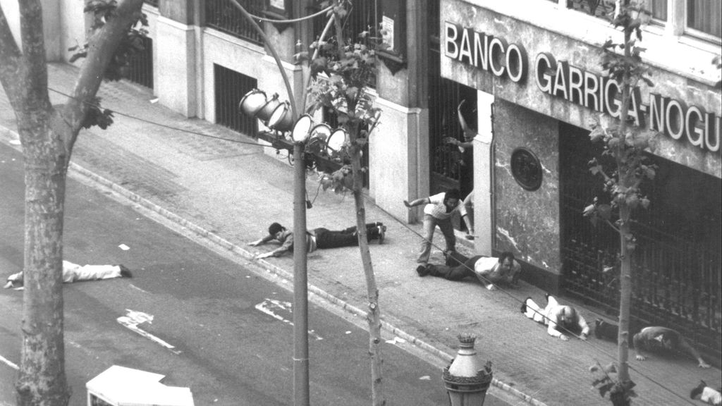 Momento de salida de algunos rehenes que se tiran al suelo para evitar ser tiroteados durante el asalto al Banco Central de Barcelona