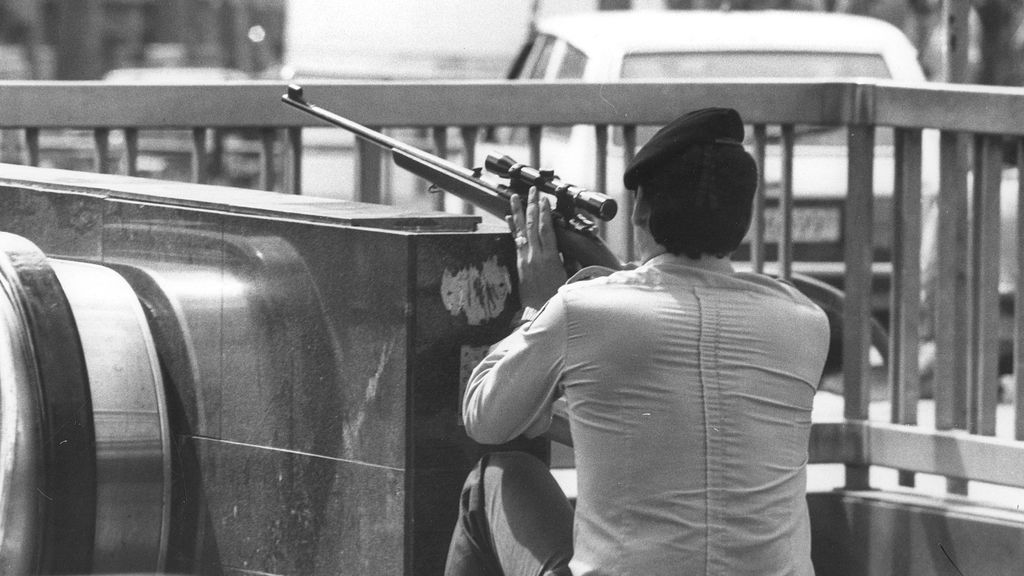 Un francotirador vigila armado junto a una salida de metro