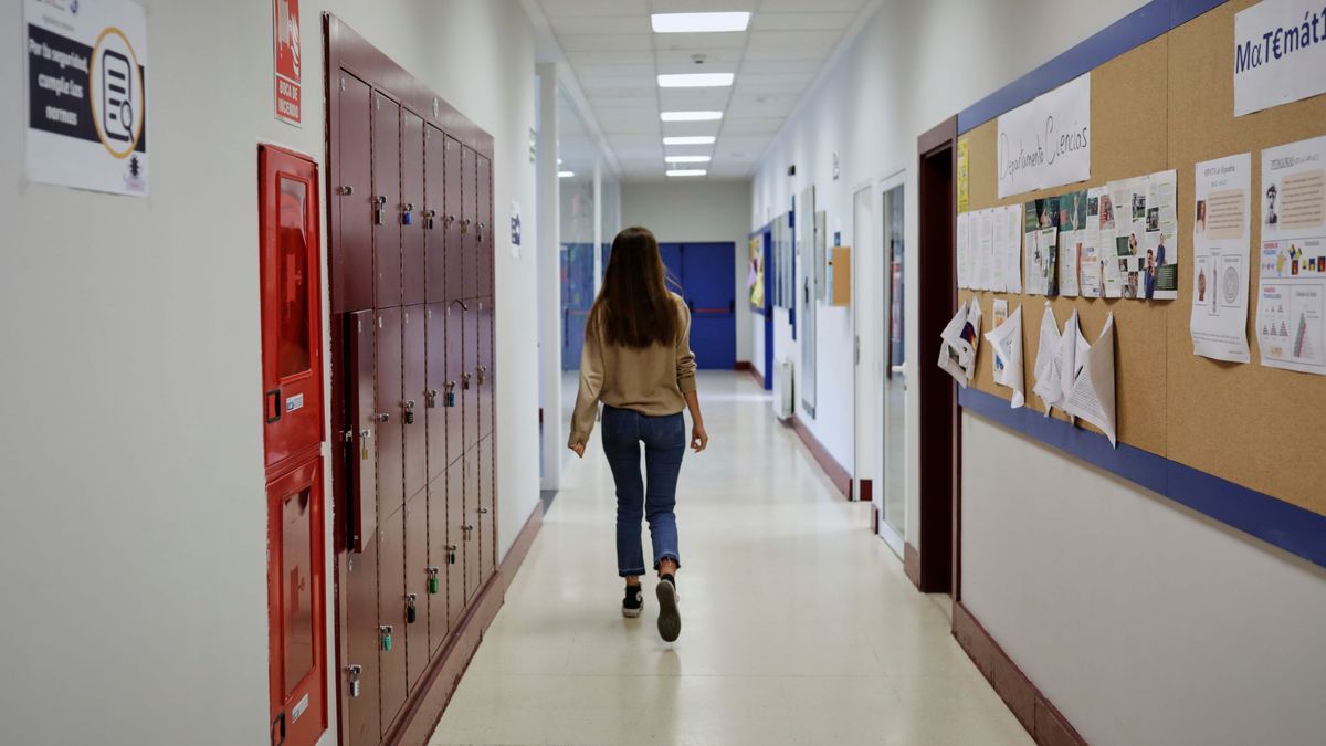 Imagen de archivo de una alumna camina por un pasillo