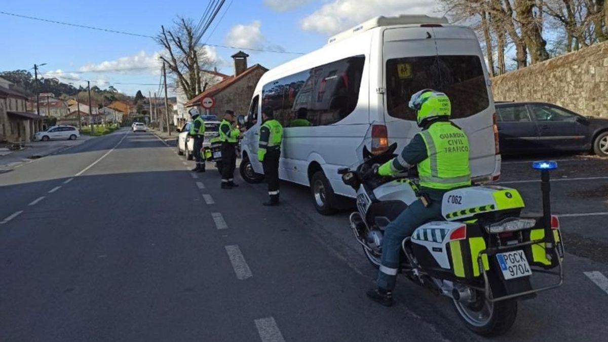 Agentes de tráfico con un microbús escolar interceptado en Padrón (A Coruña) Agentes de tráfico con un microbús escolar interceptado en Padrón (A Coruña)