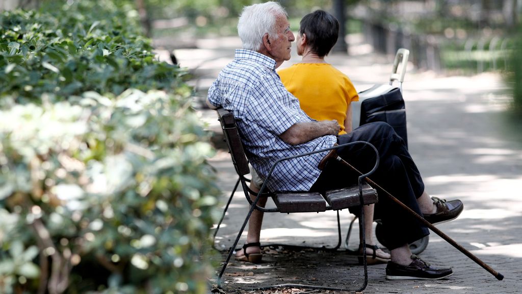 Un pensionista descansa en un banco de un parque de Madrid