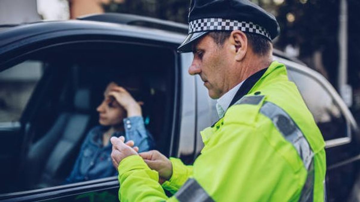 Agente de tráfico detiene a una conductora. Agente de tráfico detiene a una conductora.