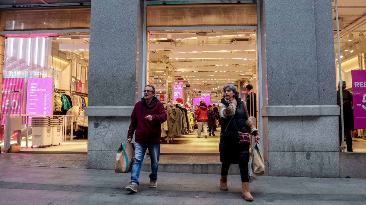 Dos personas salen de realizar compras en una tienda Dos personas salen de realizar compras en una tienda