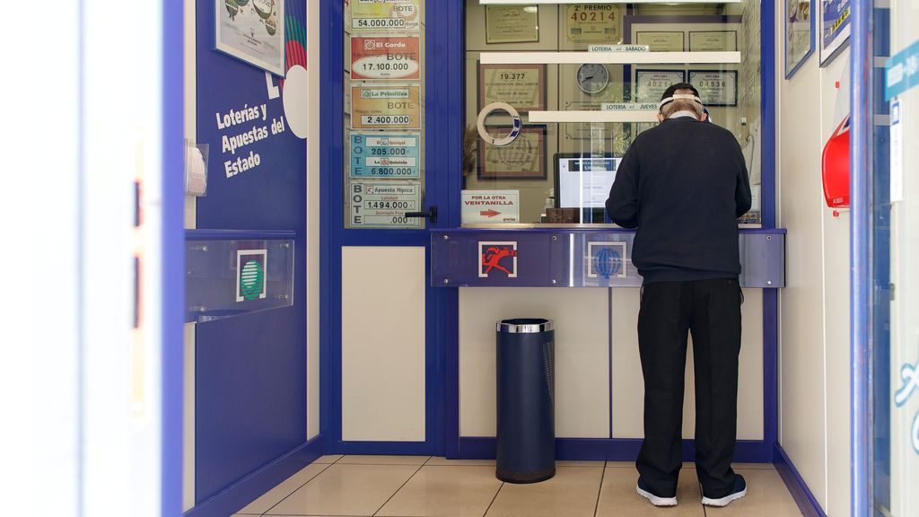 Un hombre compra un sorteo en una administración de lotería