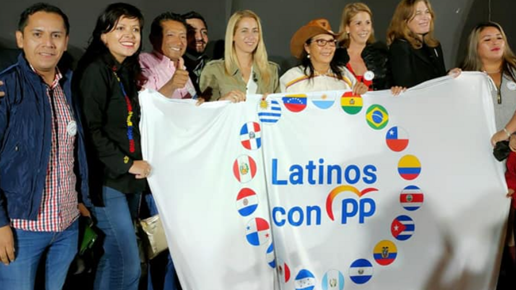 La telepredicadora Yadira Maestre porta una bandera con el lema 'Latinos con el PP'