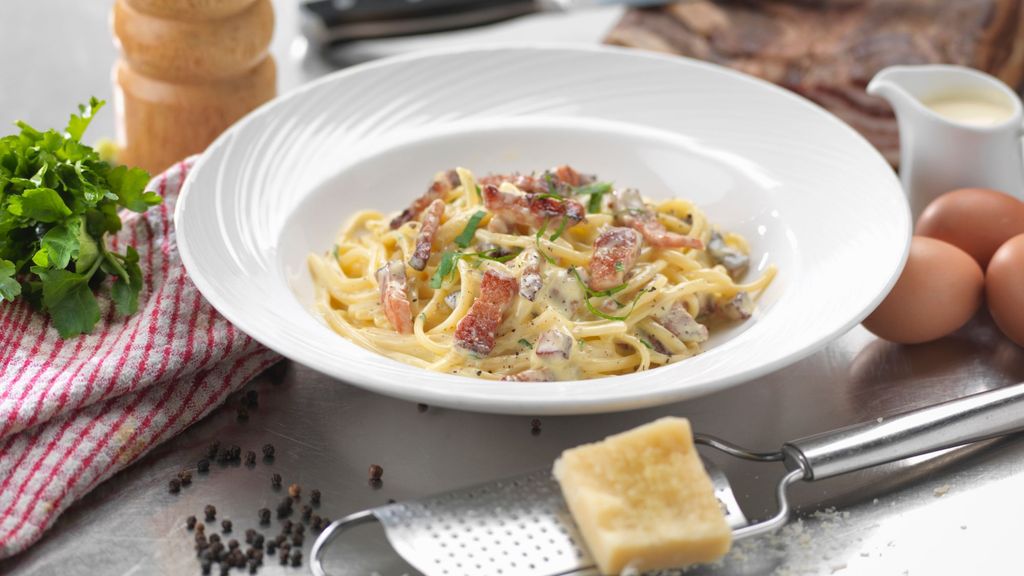 Un plato de espaguetis a la carbonara con queso parmesano