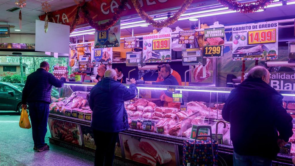 Archivo - Varias personas realizan sus compras en una tienda de comestibles, en una imagen de archivo.