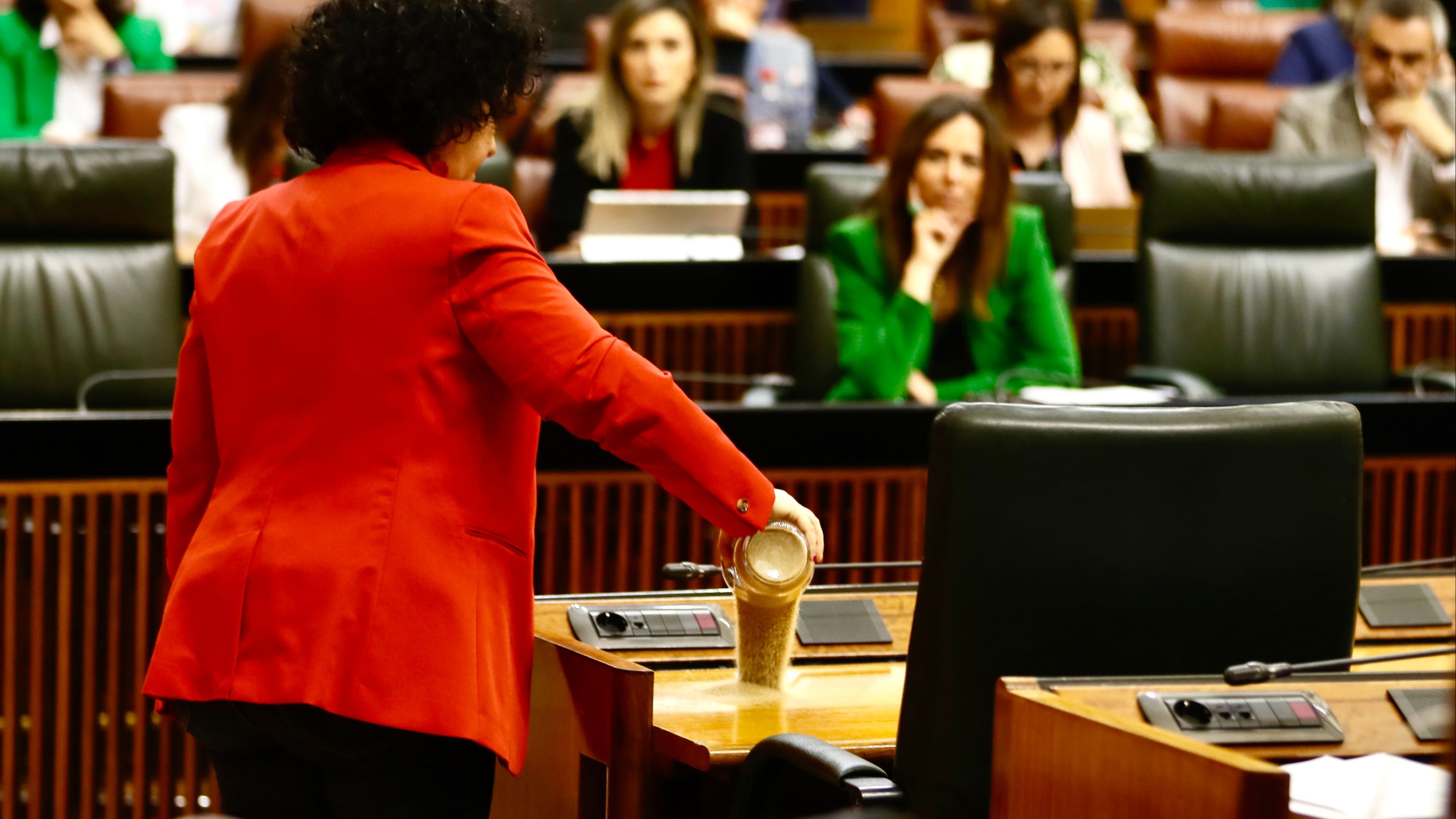 Maribel Mora arroja arena de Doñana en el escaño de Juanma Moreno