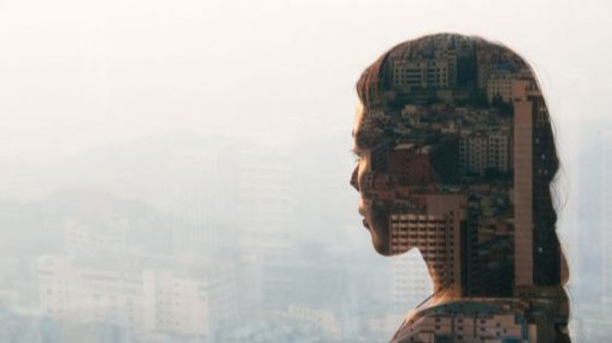 double exposure of woman looking at cityscape,shenzhen,china