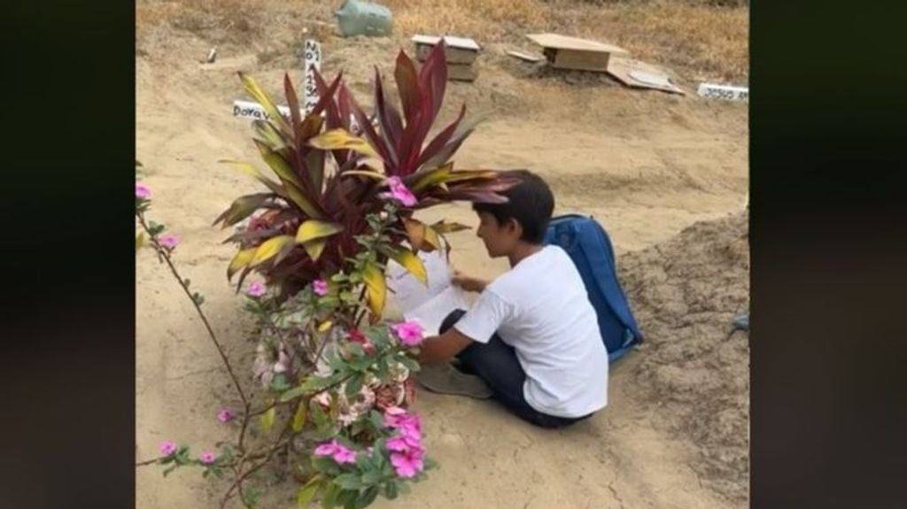 Un niño acude todos los días a hacer los deberes junto a la tumba de su madre en Colombia