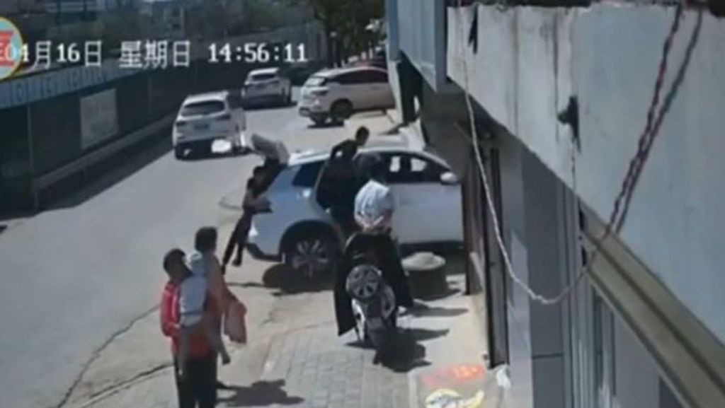 Un coche queda al borde un agujero en China y, tras conseguir sacarlo, están a punto de morir atropellados