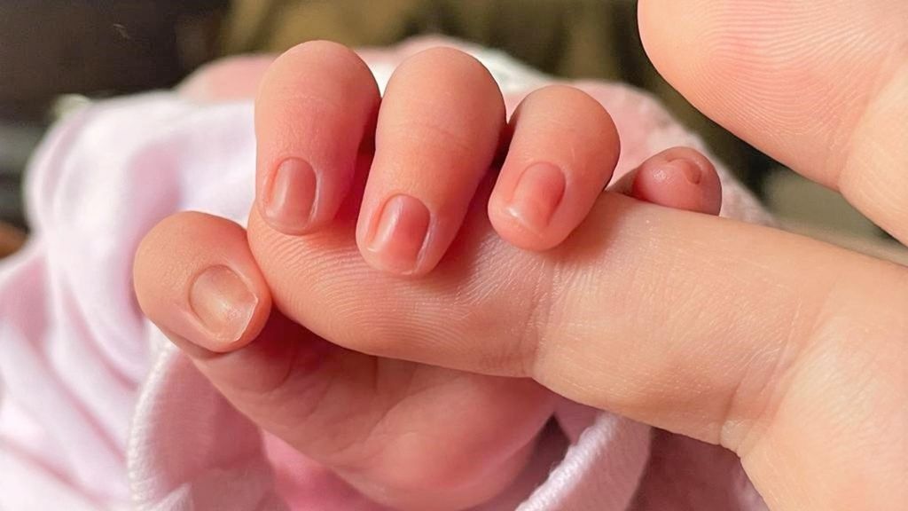 Archivo - Un bebé de pocos días de edad coge el dedo de su madre.
