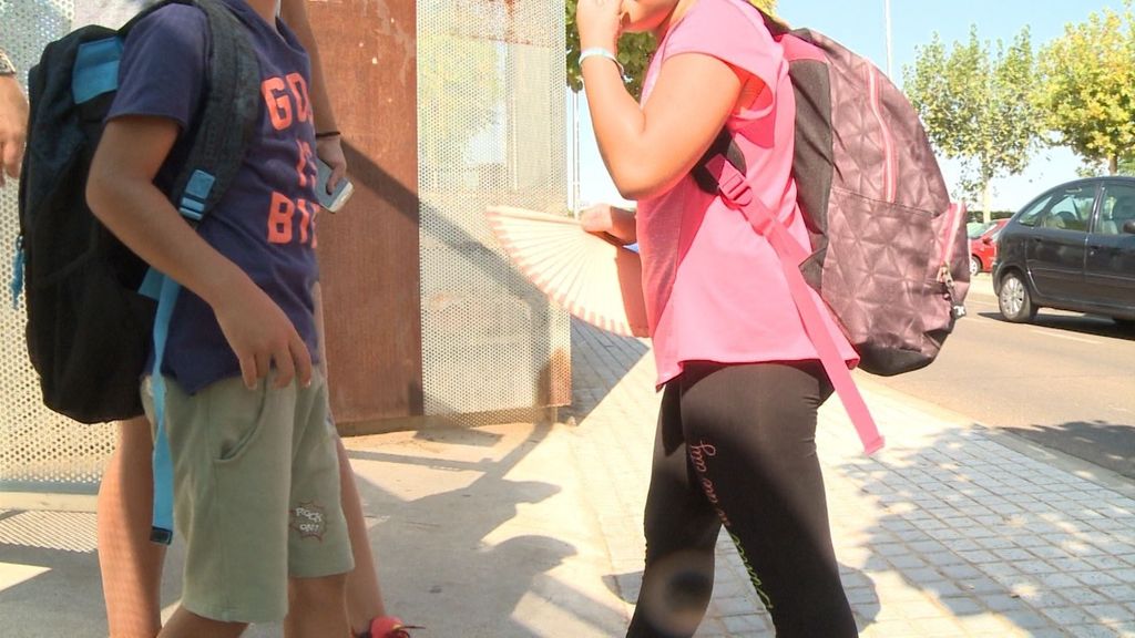 Niños con abanico en la puerta del colegio