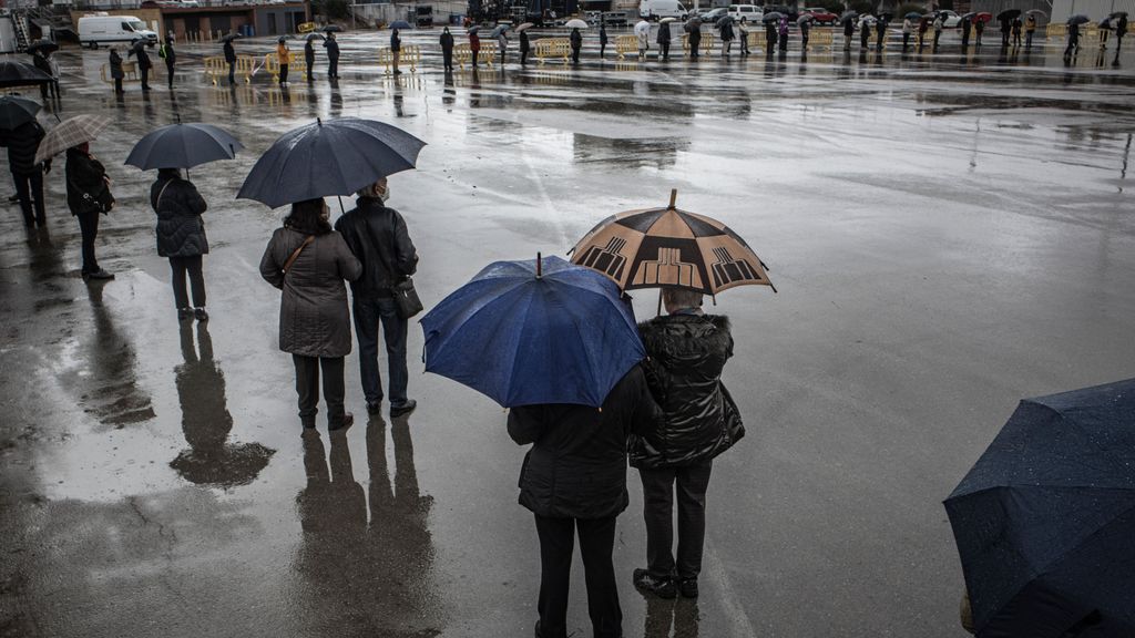 Un grupo de personas hace cola en un día lluvioso en Barcelona